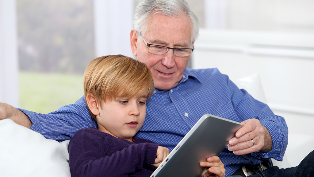 Grandfather and grandson using a tablet