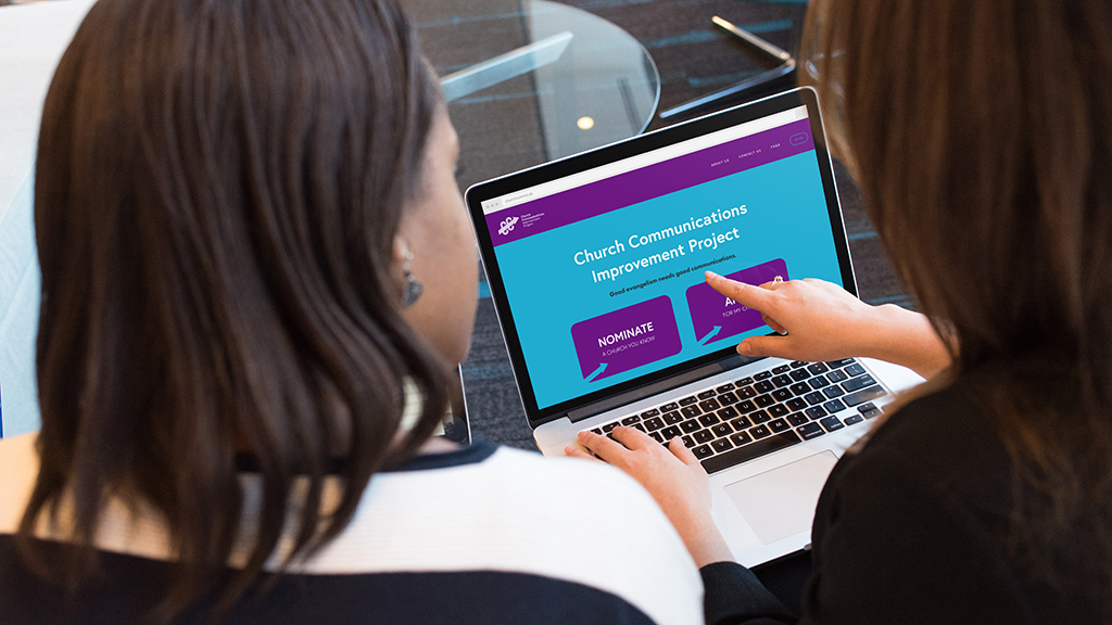 Photo of two women discussing web page on a laptop